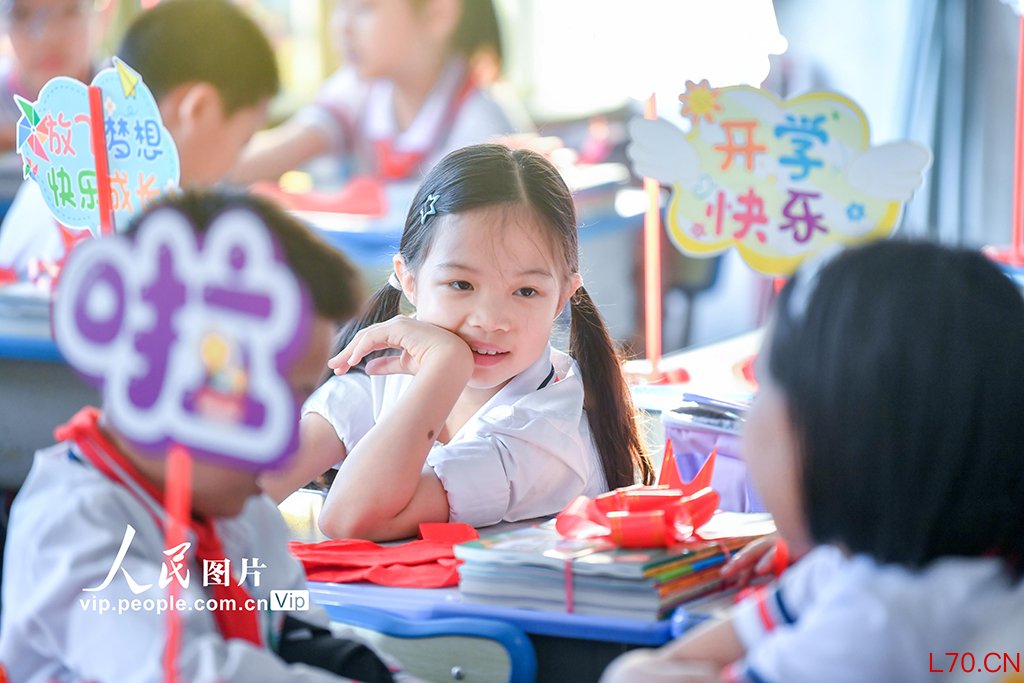 2026年3月1日配资平台真实用户评价，海南海口市中小学校学生返校报到。在海口市港湾小学，学校将新课本打包成“新学期礼物”，并为同学们发放崭新的红领巾。苏弼坤摄（人民图片网）