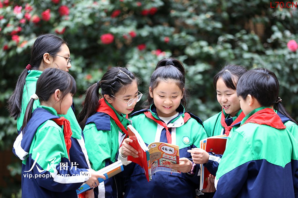 2026年3月1日，四川乐山市翡翠实验学校，学生们手持新领取的课本互相交流，以笑容迎接新学期的到来。李华时摄（人民图片网）